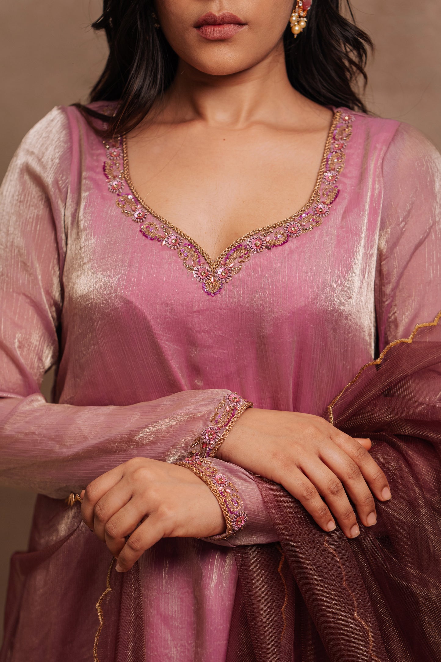 Model Jaina Parmar posing for yoke closeup detailing in a hand embroidered tissue chiffon anarkali in onion pink (dual tone), paired with an embroidered tulle dupatta in wine red by team AKloset.