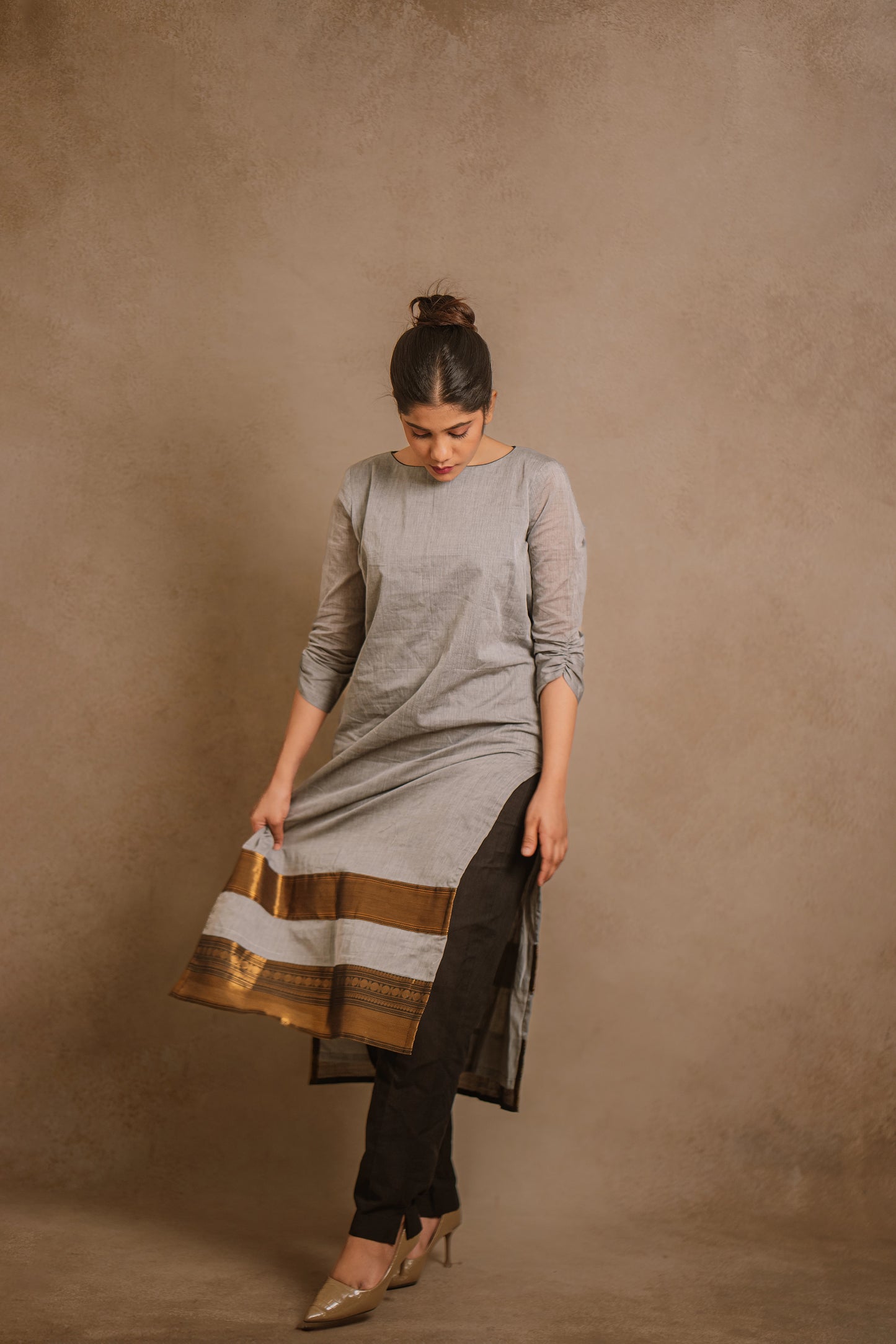 Model Jaina Parmar showcasing in an oversized gray kurti by team AKloset. A South Edit (Kanjivaram) piece is differentiated by the extravagant border native to Kanjivaram.