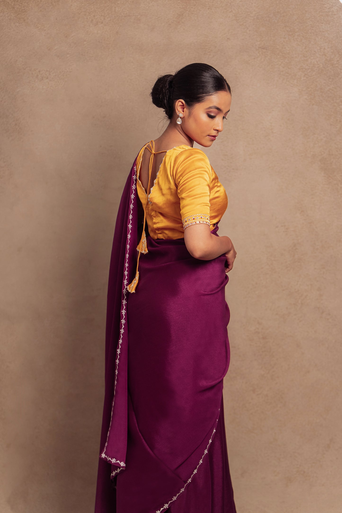 Model Krisha posing for back blouse design in embroidered shimmer chiffon saree in purple paired with an embroidered mustard yellow chanderi blouse by AKloset.
