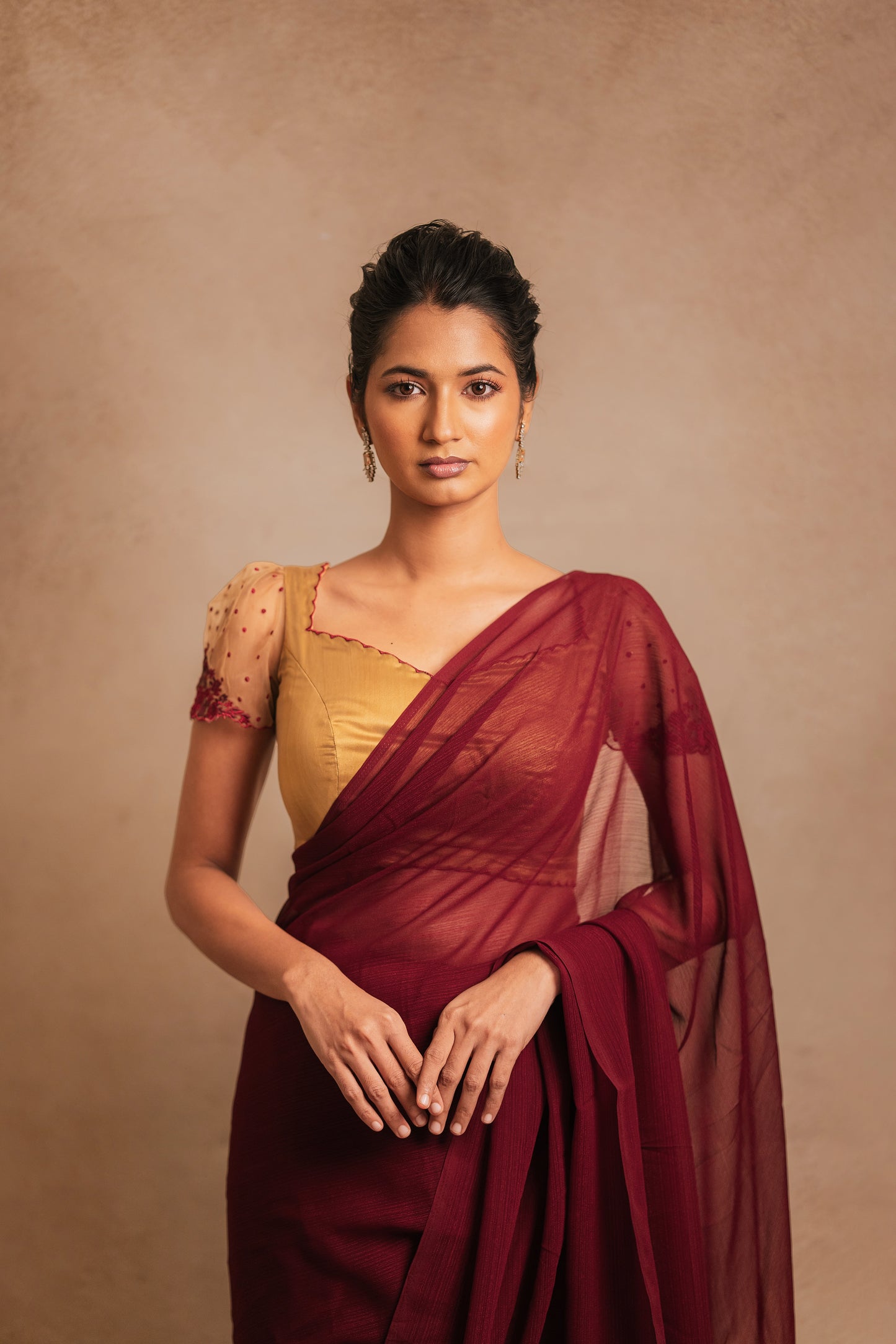 Model in a saree in maroon tulle embroidered with resham paired with an embroidered satin blouse in light brown by team AKloset.