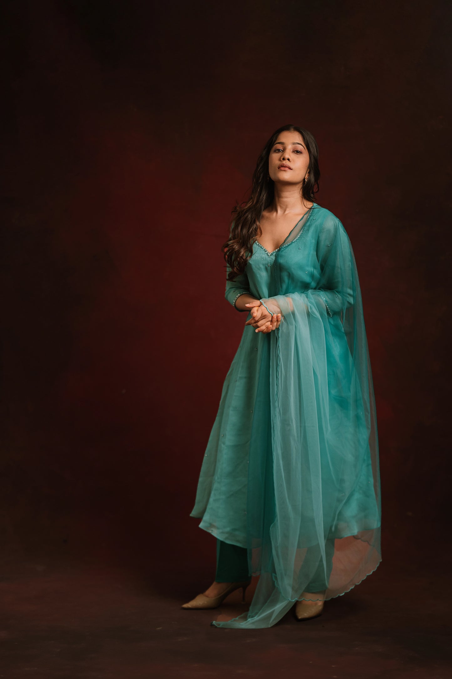 Model posing in a teal blue tissue chiffon salwar set by AKloset.