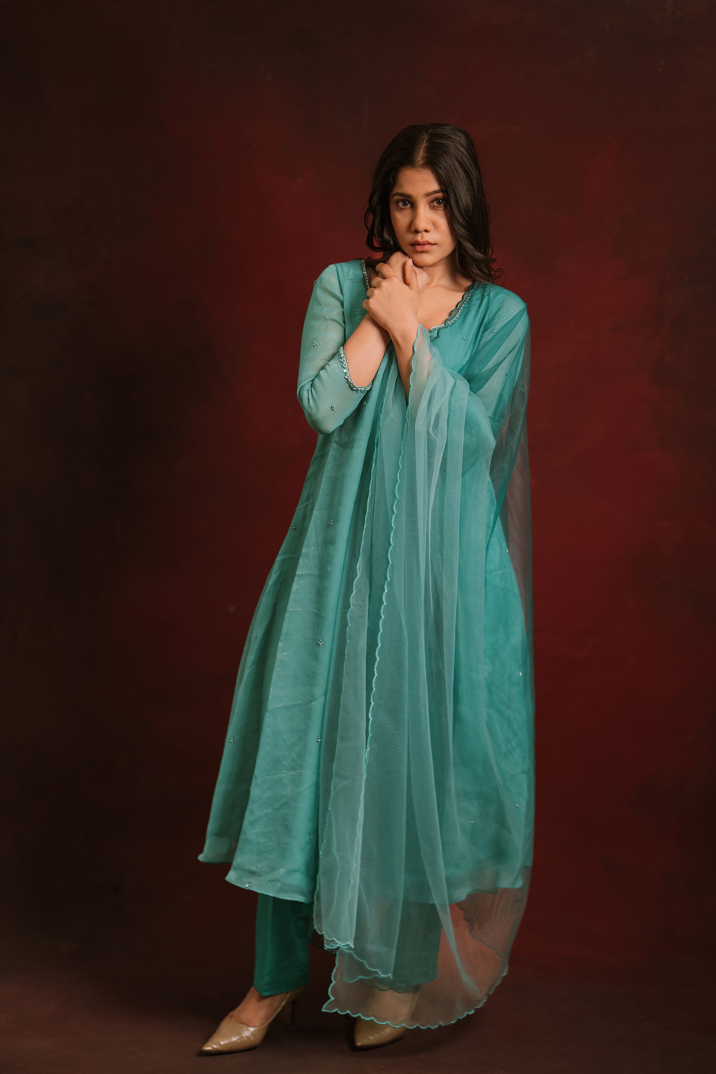 Model posing with net dupatta in teal blue tissue chiffon salwar set by AKloset.